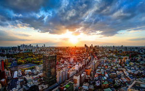 夕陽下，密集的城市景觀中摩天大樓和住宅建築在戲劇性的雲層下。