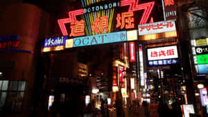 霓虹燈照亮的東京夜晚街道，閃爍的招牌和行人。 — 黑暗日系 壁紙