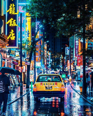 黃色的士在雨夜的霓虹燈街道上，有撐傘的行人。