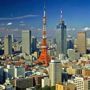 橙色的東京塔在清澈的藍天下矗立於摩天大樓之間 — 建築 壁紙