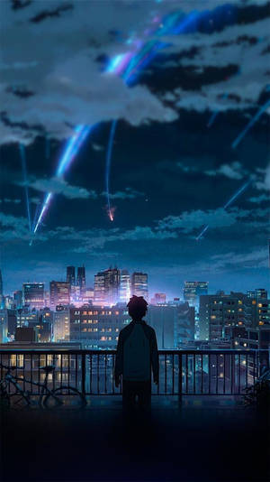 一個男孩在屋頂陽台上觀看發光的流星在夜間劃過城市天際線。