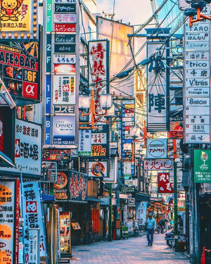 日落時分繁忙的東京小巷，閃爍著霓虹燈招牌和架空電線。