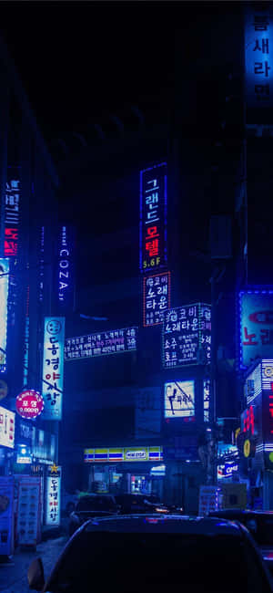 霓虹招牌照亮夜晚潮濕的城市小巷和停泊的汽車。 — 日本 壁紙