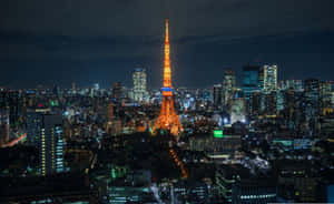 夜晚的東京鐵塔被點亮，周圍環繞著閃爍的城市燈光。 — 城市 壁紙