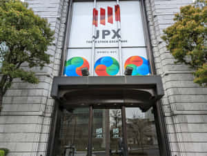 東京證券交易所大樓入口，帶有市場細分標誌和樹木