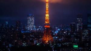 東京塔在夜間亮起，背景是閃爍的城市燈光。