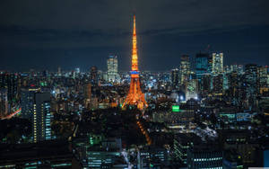 夜晚的東京鐵塔，周圍環繞著閃爍的城市燈光。 — 日本 壁紙