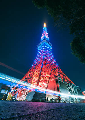東京塔在夜晚發出紅藍光芒，伴隨著交通光跡。 — IQOO Pad5c 壁紙