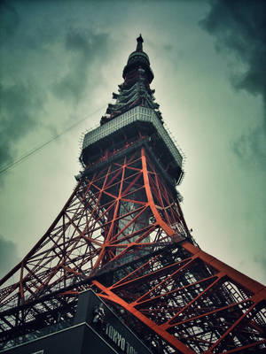 東京鐵塔的紅色鋼鐵框架映襯著多雲的天空 — 日本 壁紙