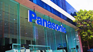 Panasonic企業大樓，玻璃外牆和藍色標誌，周圍環繞樹木。