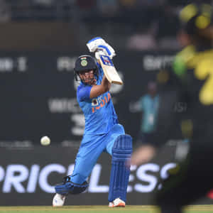 身穿藍色球衣的女板球運動員在夜間比賽中擊球。 — 巴基斯坦板球 壁紙