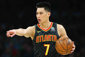 籃球運動員穿著亞特蘭大球衣，比賽中持球並指向。 — 亞特蘭大勇士 GIF 壁紙