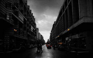 黃昏時分，雨中的城市街道上行人與汽車的剪影。 — 暗色 壁紙