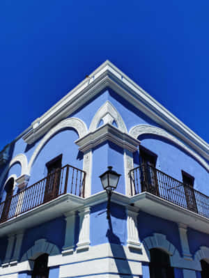 藍色殖民建築，白色細節和陽台，在明亮的天空下