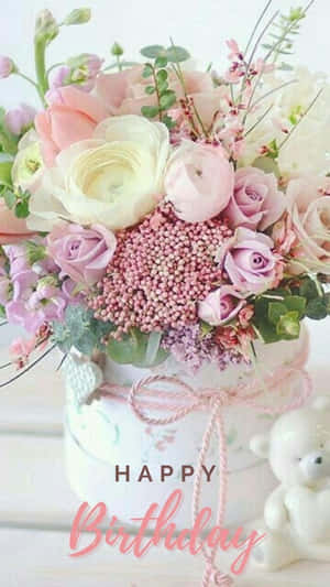 生日花束，有粉紅玫瑰和漿果，旁邊有一隻泰迪熊。