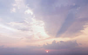 夕陽穿透雲層，呈現粉彩天空