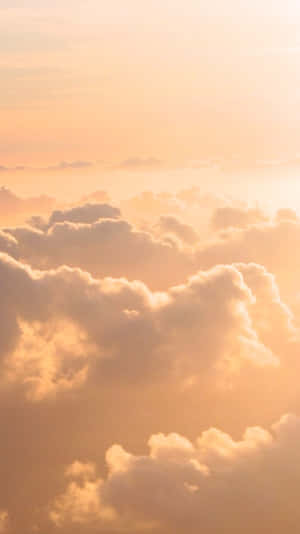 金色雲朵漂浮在日出或日落時溫暖發光的天空中。 — 天空美學 壁紙