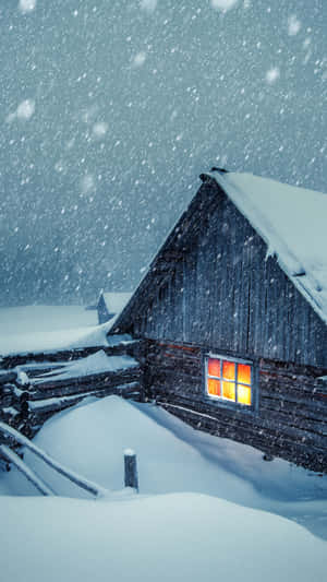被雪覆蓋的小屋，在冬季風暴中窗戶發光