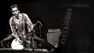 Chuck Berry 在舞台上彈結他，背景是磚牆，他的名字被寫出來。