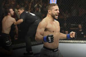 UFC拳手在八角籠內握緊拳頭，以怒吼的表情慶祝勝利。