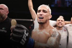 UFC拳手在八角籠內與團隊慶祝勝利。