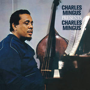 Charles Mingus 在攝影棚肖像中彈鋼琴，身後有低音提琴