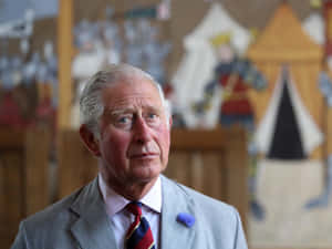 英皇查理斯三世身穿正裝，佩戴藍色花卉胸針，室內。 — 政治 壁紙