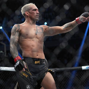 UFC拳手在八角籠內舉臂慶祝勝利。