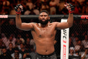 UFC拳手在八角籠中高舉雙臂慶祝勝利。