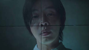 一個人的臉在昏暗的藍綠色燈光下被網格圖案分割。