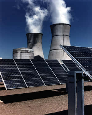 太陽能板位於排放蒸汽的核電廠冷卻塔前。