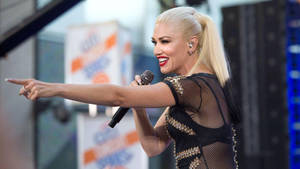 Gwen Stefani 在現場演唱會表演中唱歌並指向粉絲。