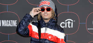男士身穿 Moncler 外套在活動中調整紅色太陽眼鏡。