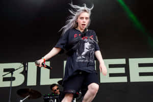 Billie Eilish 在舞台上熱情地唱歌，風吹動她的頭髮。