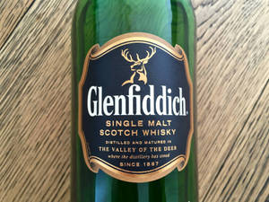 木質表面上綠色 Glenfiddich 威士忌酒瓶標籤。