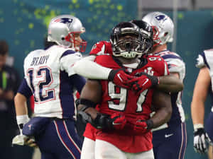 足球員在夜間球場燈光下慶祝一次進攻。 — NFL 美式足球 GIF 壁紙