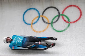 格魯吉亞雪橇運動員在可見奧運五環的冰道上飛馳。