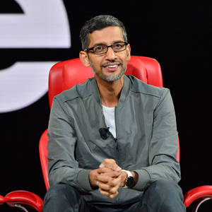Sergey Brin 在科技活動中坐在紅色椅子上微笑。