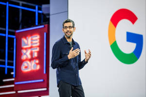 Google行政總裁Sundar Pichai在科技活動中發言，背景有霓虹燈標牌和Google標誌。