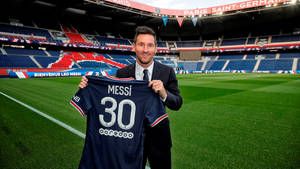 里奧·美斯在球場上手持他的PSG 30號球衣。