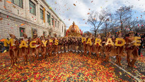 Macy's Parade 表演者身穿秋季服裝，在街道上飄落的五彩紙屑中。