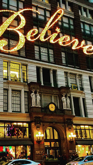 Macys 百貨公司入口，黃昏時「Believe」標誌亮起。