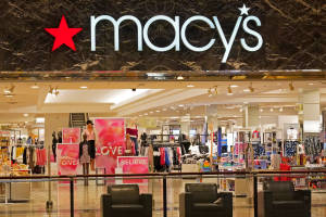 Macy's 百貨公司入口，有購物者和內部可見的服裝陳列。