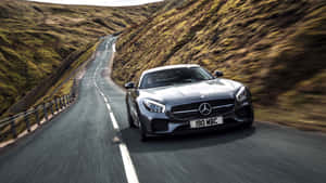 日落時分，銀色 Mercedes-AMG GT 在蜿蜒的山路上疾馳。