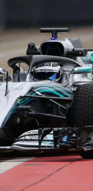 F1賽車在賽道上高速行駛，帶有紅色路緣石和輪胎水花。