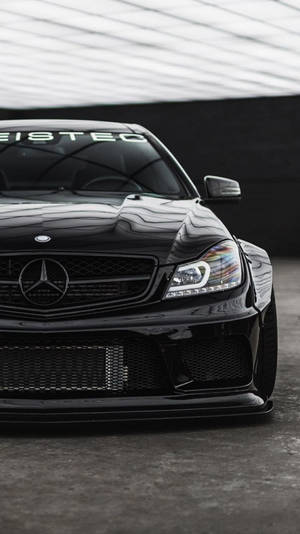 黑色 Mercedes 跑車經過自訂改裝，停放在遮陽篷下。
