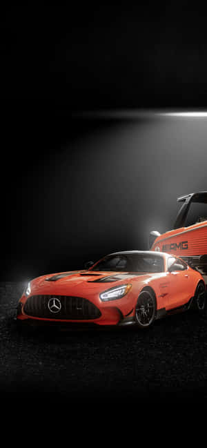 橙色 Mercedes-AMG GT 跑車在黑暗工作室中被聚光燈照亮。