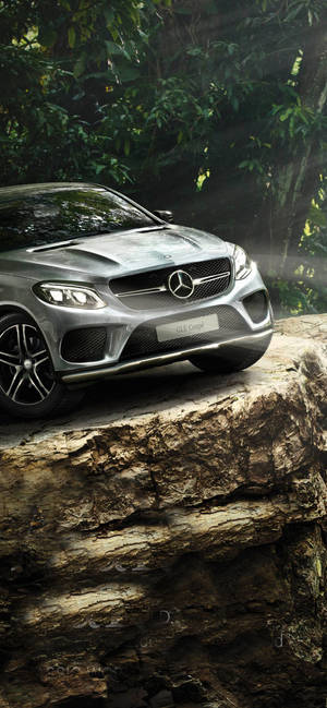 銀色 Mercedes-AMG GLE Coupe 停泊在森林中的岩石露頭上。