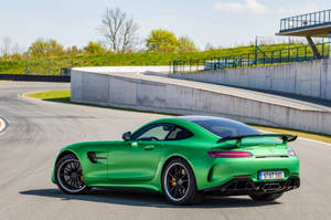 日落時分在賽道上奔馳的綠色Mercedes-AMG GT S。 — 汽車 壁紙