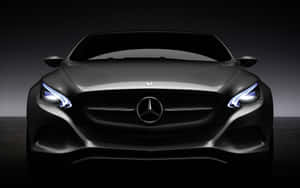 黑色梅賽德斯-奔馳汽車在黑暗工作室中亮著車頭燈的前視圖。